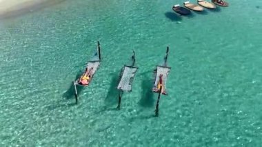 Güneş arayıcıları Tayland 'da balayına çıkmış çeşitli erkek ve kadınlar olan Koh Kood cennetinde dinlenirken hamaklar kristal berrak sularda hafifçe sallanıyor.