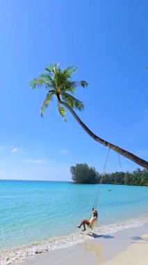 Koh Kood 'da sakin bir öğleden sonra, bir palmiye ağacından sallanan nazik bir salıncak. Sakin turkuaz dalgalar ve yumuşak kum rahatlama ve mutluluk anları için mükemmel bir zemin oluşturur..