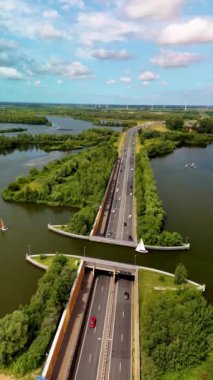 Veluwemeer Aqueduct, hareketli bir yolun üzerinde sakin bir su yolunun aktığı yer. Doğa ve altyapının birleşimini deneyimleyin. Hollanda 'daki otoyolun üstündeki gölde su kemeri.