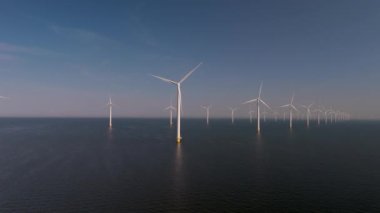 Dev yel değirmeni türbinleri Hollanda 'nın sakin sularında, yenilenebilir enerji üretmek için güçlü rüzgarları yakalarlar. Bu etkileyici düzen doğa ve teknolojinin uyumunu gözler önüne seriyor..