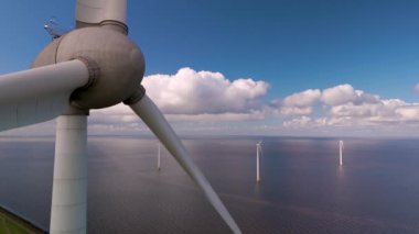 Güçlü yel değirmeni türbinlerinin doğal enerjiyi çarpıcı bir bulut zeminine ve açık sulara karşı kullandıkları Hollanda 'nın canlı enerji manzarasını deneyimleyin..