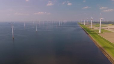 Hollanda kıyı şeridi boyunca rüzgar türbinleri, okyanusta yel değirmenleri, yeşil enerji üreten yel değirmenlerinin insansız hava aracı görüntüsü ve Hollanda 'da denizde izole edilmiş yel değirmenleri bulunur..