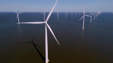 Hollanda topraklarında dik duran yel değirmeni türbinlerinin nefes kesici manzarasını keşfedin. Bu devler yenilenebilir enerjiyi kullanıyorlar, sakin manzarayı güzelleştirirken sürdürülebilir bir geleceğe katkıda bulunuyorlar.