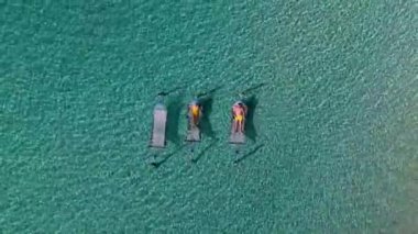 İnsanlar Koh Kood Adası 'nın berrak sularının üzerindeki hamaklarda güneşlenmeyi severler. Sakin atmosfer ve turkuaz renkler Tayland 'da mükemmel bir tropikal kaçış sağlar.
