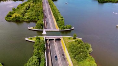 Dikkat çekici Veluwemeer Aqueduct 'a tanık olun, araçların su altından geçmesine izin veren bir mühendislik harikası. Güzel Hollanda manzarasında yer alan bu yapı, yenilikçi tasarımın altını çizmektedir..