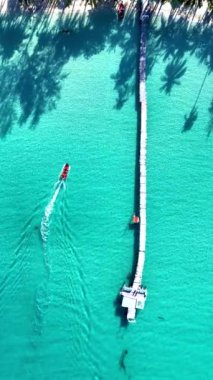 Koh Kood Tayland 'ın göbeğinde, canlı turkuaz sular sıcak güneşin altında uzun bir ahşap rıhtımla karşılaşır. Küçük bir tekne süzülüyor, ışıkta dans eden dalgalar yaratıyor..