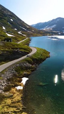 Kıyı şeridini saran kıvrımlı bir yolun yer aldığı nefes kesici Norveç manzarası. Langvatnet Geiranger Norveç