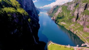 Norveç 'te sarp kayalıklar ve yemyeşil yeşilliklerle çevrili sakin bir fiyortun çarpıcı manzarasını deneyimleyin. Lysefjorden Lysebotn Norveç