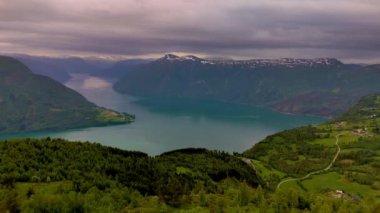 Norveç 'in nefes kesen fiyortlarını keşfedin. Yeşilliğin sakin sularla buluştuğu ve görkemli dağların karamsar gökyüzüne karşı dik durduğu. LustraFjord Molden Norveç Yürüyüşü