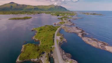 Norveç 'in çarpıcı güzelliğini keşfedin, kıvrımlı bir yol kıyı şeridini kucaklıyor, canlı yeşillik ve sakin mavi sular sergiliyor. Atlantik Okyanusu yolu Atlanterhavsveien Norveç 'te