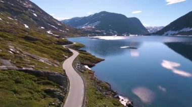 Turkuaz suların yükselen dağlarla buluştuğu Norveç 'in nefes kesici güzelliğini keşfedin. Göz kamaştırıcı doğal manzaralarla çevrili manzaralı yollarda huzurlu bir yolculuk yaşayın..