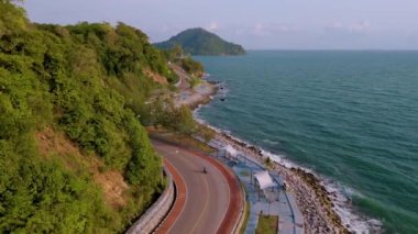 Chonburi 'nin dolambaçlı yolu, verimli yeşillikler ve gün batımında Tayland Körfezi' nin sakin mavi sularıyla çevrili. Doğu Tayland 'daki Khung Wiman Körfezi sahil yolu.