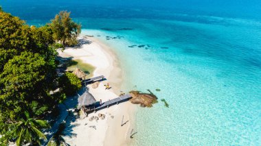 Rayong Tayland 'daki Koh Munnork Adası' nın dingin cennetini keşfedin. Altın kumun turkuaz dalgalarla buluştuğu yer. Titreyen avuçların altında rahatla ya da güneşli bir günde davetkâr denize dal..