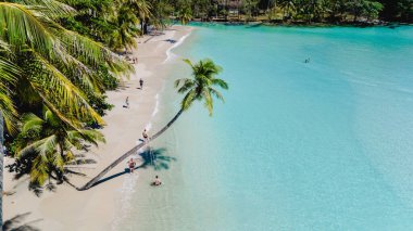 Visitors delight in the tranquil beauty of Koh Kood's white sandy beaches, surrounded by vibrant greenery and calm turquoise waters. A perfect getaway for relaxation and adventure in nature. clipart