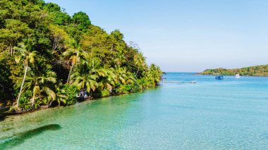 Kristal berraklığında sular Koh Kood 'un kumlu kıyılarına çarpar, gür palmiye ağaçları hafif esintide sallanır. Ziyaretçiler, doğanın ihtişamıyla çevrili huzurlu bir kaçışın tadını çıkarıyorlar..