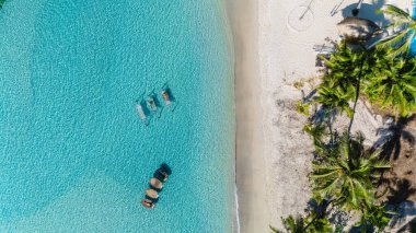 Ziyaretçiler, Tayland 'ın Koh Kood kentindeki sakin suların üzerinde uzanmış, nefes kesen palmiye ağaçları ve yumuşak beyaz kumlarla çevrili, okyanusta bir çift hamak.