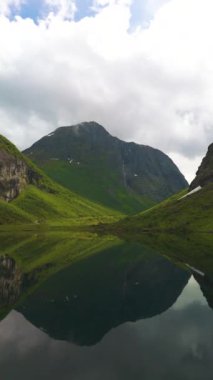 Serin bir göl boyunca yemyeşil dağların yükseldiği Norveç 'in nefes kesen doğal güzelliğini tecrübe edin..
