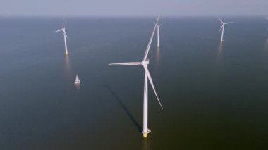 Okyanustaki yel değirmeni parkı, yeşil enerji üreten yel değirmeni türbinlerinin insansız hava görüntüsü, Hollanda 'da denizde izole edilmiş yel değirmenleri..