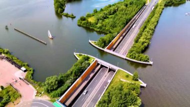 Bu büyüleyici manzara Veluwemeer Aqueduct Hollanda 'yı gözler önüne seriyor, burada bir otoyol zarif bir şekilde manzaralı bir su yolunun altından geçiyor. Yeşilliklerle çevrili bu mimari mucize davet ediyor.