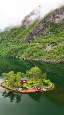 Yükselen tepelerin ortasında, sakin bir göl boyunca büyüleyici kulübeler sergileyen tuhaf bir ada. Sakin sulardaki yemyeşil aynalar huzur ve güzelliğin bir resmini oluşturuyor. Lovrafjorden Norveç