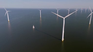 Nazik rüzgarlar, görkemli yel değirmeni türbinleriyle süslenmiş Hollanda topraklarında süzülüyor. Hollanda 'daki doğa ve teknolojinin uyumunu gösteren küçük bir tekne sakin sularda geziniyor.