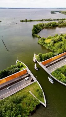 Hollanda 'daki sıradışı Veluwemeer Aqueduct' u keşfedin. Araçların göl altında seyahat ettiği ve teknelerin üzerinde süzüldüğü yer. Bu mimari mucizeyi sakin sularda ve yemyeşil sularda tecrübe edin.