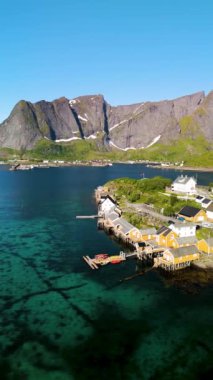 Norveç kıyı şeridinin güzelliğini, suların kenarlarında parlak sarı evler, görkemli dağlar ve kristal berrak sularla çevrili. Sakrisoy Lofoten 