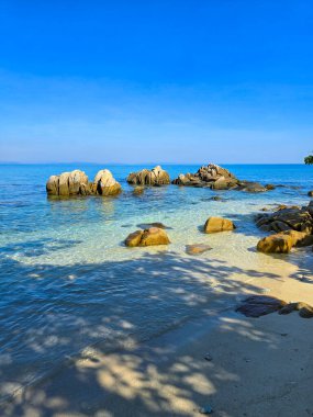 Berrak turkuaz sular, güneşli kayaların güzel bir kıyı manzarası oluşturduğu Koh Munnork Adası 'nın kumlu kıyılarına nazikçe uzanır. Dinginlik ve güzellik bu tropikal kaçışı tanımlar.