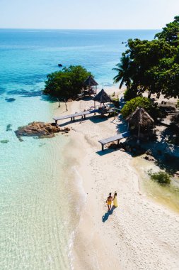 Koh Munnork Adası 'nın el ele tutuşmuş el ele gezen çiftler, sallanan palmiye ağaçlarının altında sıcak güneşin ve dingin suların tadını çıkarıyorlar. Huzurlu bir ortam rüya gibi bir kaçış yaratır..