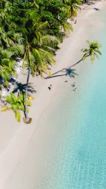 Güneş ışığı, ziyaretçilerin sakin suların tadını çıkardıkları Koh Kood 'un yumuşak kumlu kıyı şeridinde dans ediyor. Bereketli palmiye ağaçları rüzgarda hafifçe sallanarak tropik bir cennet yaratıyor..