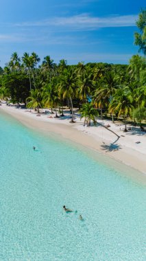 Yumuşak beyaz kumlar Koh Kood 'da canlı bir mavi gökyüzünün altında turkuaz sularla karşılaşıyor. Huzurlu kumsalcılar ılık güneşin ve yumuşak dalgaların tadını çıkarın. Rüzgarda sallanan palmiye ağaçları arasında..