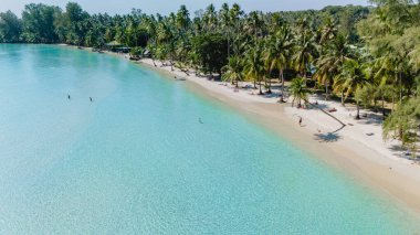 Koh Kood, Tayland 'ın el değmemiş kıyılarında turkuaz suların kumlu bir plaja çarptığı yerde rahatlama başlar. Güneşlenenler yemyeşil palmiyelerle çevrili sakin atmosferin tadını çıkarırlar..