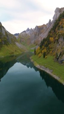 İsviçre, Falensee 'nin nefes kesici güzelliğini yaşayın. Sonbahar, manzarayı canlı renklerle resmediyor. Sakin sular, sakin bir kaçışla dağların zirvelerini yansıtıyor..