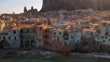 Altın saat boyunca Sicilya 'nın nefes kesici sahil kasabası Cefalu' yu keşfedin, ilginç mimari sergiler, kıyıya vuran dalgalar ve görkemli uçurumlar..