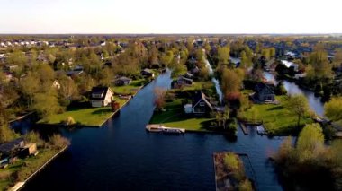 Hollanda 'da bahar mevsiminde büyüleyici kanallar boyunca uzanan büyüleyici evlerin sakin manzarası, Vinkeveense Plassen Hollanda