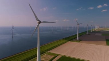 Görkemli rüzgar türbinleri Hollanda kıyıları, okyanustaki yel değirmeni parkı, yeşil enerji üreten yel değirmenleri ve denizde izole edilmiş yel değirmenleri. 