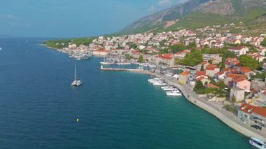Hırvatistan 'ın çarpıcı rıhtımında canlı binalar ve sakin sular sergilenirken, limanda kayıklar hafifçe sallanıyor. Brac Adası