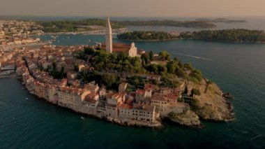 Hırvatistan 'ın Rovinj kentinin büyüleyici mimarisi ve canlı rıhtımının üzerinde güneş batarken nefes kesen manzarasına hayret ediyorum. Adayı çevreleyen sakin sular sakin bir atmosfer yaratıyor..