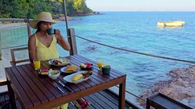 Bir gezginin, Koh Kood Adası 'nın çarpıcı mavi sularıyla çevrili taze bir kahvaltıdan keyif aldığı huzurlu bir sabahın tadını çıkarın. Tropik cennet Tayland 'da mükemmel bir zemin hazırlıyor.