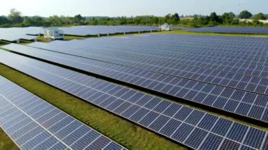 Tayland 'da güneş panellerinden oluşan sıra sıra güneş ışığından yararlanarak sürdürülebilir enerjiye katkıda bulunan geniş bir güneş parkını keşfedin..