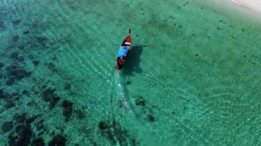 Koh Lipe adasının büyüleyici turkuaz sularını, dingin denizde süzülen geleneksel bir uzun kuyruklu tekne olarak tecrübe edin. Güzel manzaraların ve canlı deniz yaşamının tadını çıkar..