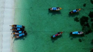 Tayland 'daki Koh Lipe' nin nefes kesici güzelliğini keşfedin, renkli teknelerin turkuaz sularda dinlendiği. Çarpıcı manzara keşfedilmeyi bekleyen tropik bir cenneti sergiliyor..