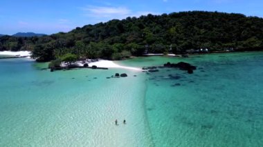 Tayland 'da saklı bir cennet olan Koh Mak' ın huzur dolu cazibesini keşfedin. Kristal berrak sular dingin bir zemin oluştururken iki maceracı sahilde geziniyor. Doğa güzelliği bekliyor..