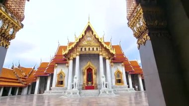Bangkok 'ta gökyüzüne karşı karmaşık tasarımları olan görkemli tapınak yapıları yükseliyor. Bangkok Tayland 'daki Wat Benchamabophit tapınağı, Tayland' daki Mermer Tapınak