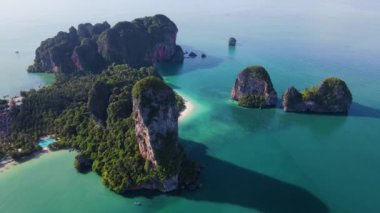 Yükselen kireçtaşı kayalıklarının gök mavisi sularla buluştuğu Railay plajı Krabi Tayland 'ın çarpıcı doğal güzelliğine tanık olun. Railay Sahili 'nin insansız hava görüntüsü