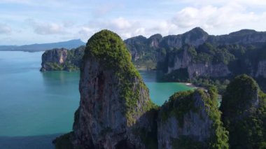 Railay Sahili Krabi Tayland 'ın büyüleyici doğal güzelliğini tecrübe edin. Görkemli kireçtaşı kayalıkları kristal berrak sulardan ve yemyeşil alandan dramatik bir şekilde yükseliyor..