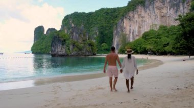 Çift, Koh Hong Krabi 'nin el değmemiş plajlarında romantik bir yürüyüş yapmayı seviyor. Mavi sular ve gür uçurumlar dinlenmek için mükemmel sakin bir atmosfer yaratır.. 