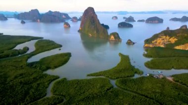 Güneş sakin suların üzerinde yükselirken Tayland, Krabi 'nin nefes kesici güzelliğine tanık olun. Phangnga Körfezi
