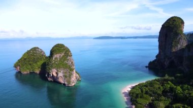 Turkuaz sulardan yükselen görkemli kayalıklar gibi Railay plajı Krabi 'nin güzelliğine dalın. Bereketli yeşillik, güneşli bir gökyüzünün altındaki bu tropik cennette macera ve rahatlamaya davetiye çıkarıyor..