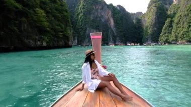 Krabi Tayland 'ın çarpıcı zümrüt sularında yelken açan bir gezgin, Koh Phi Adası' nın sakinliğini kucaklarken yüksek kireçtaşı uçurumlarının nefes kesici manzaralarından zevk alır.